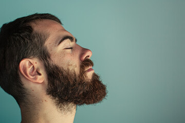 Fototapeta premium A close up of a man with beard and closed eyes looking to a side