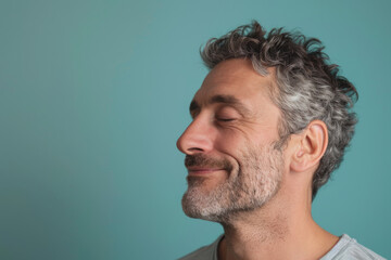 Obraz premium A close up of a man with beard and closed eyes looking to a side
