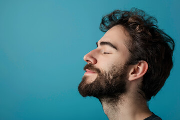 Fototapeta premium A close up of a man with beard and closed eyes looking to a side