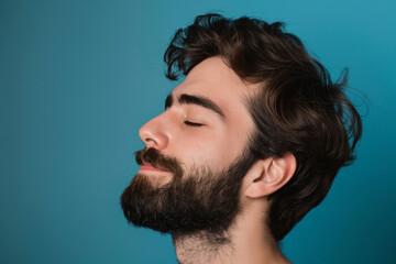 Obraz premium A close up of a man with beard and closed eyes looking to a side