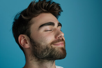 Obraz premium A close up of a man with beard and closed eyes looking to a side