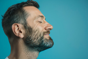 Obraz premium A close up of a man with beard and closed eyes looking to a side