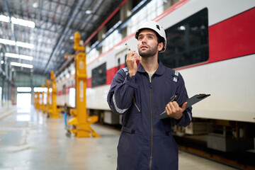 Technician or worker using walkie talkie and talking about work at construction train station