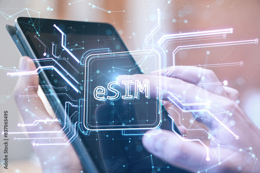 Poster close up of male hands using tablet with creative glowing esim hologram on blurry background. embedd