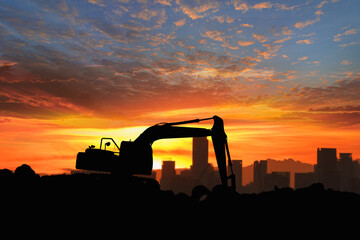 Crawler excavator  silhouette are digging the soil in the construction site  on the  sunset sky background