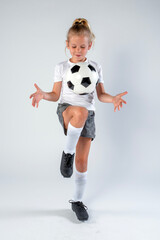 Girl youth soccer player practicing her juggling skills by bouncing a soccer ball off her thigh
