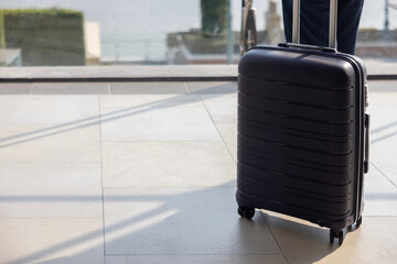 A black suitcase is sitting on a tiled floor. The suitcase is open and the person who owns it is...