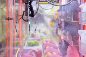 A claw machine with a pink stuffed animal in the middle