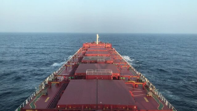 A merchant ship underway at sea, view of deck from bridge