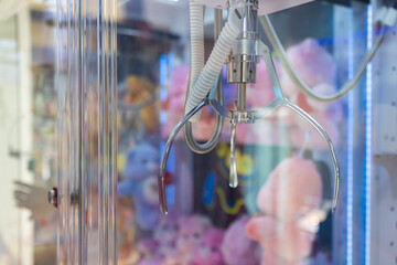 A claw machine with a pink stuffed animal dolls in the middle.