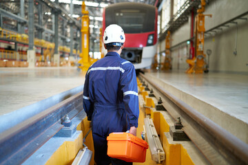 back technician or engineer holding tool box for fixing the train at construction site