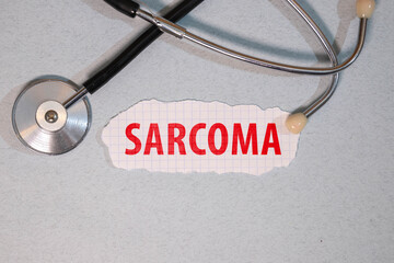 SARCOMA word on a notebook with medical equipment on background