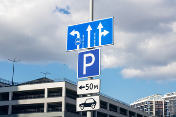 A blue parking sign with arrows indicating right direction