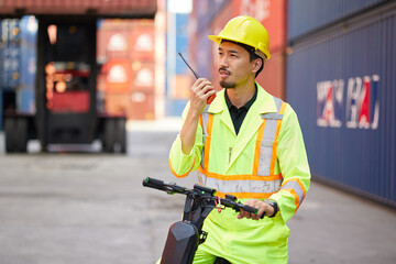 worker or engineer using walkie talkie and talking about work in containers warehouse storage