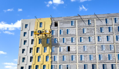 Facade Insulation. Suspended cradle mobile scaffolding platform for construction work at height....