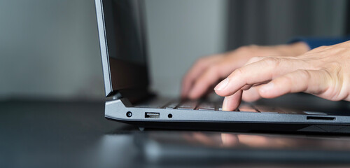 Shot of an unrecognizable businessman working on his laptop in the office.