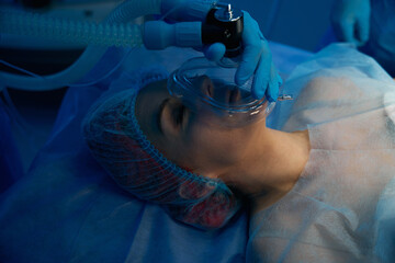 Anesthetist preparing female patient for medical operation