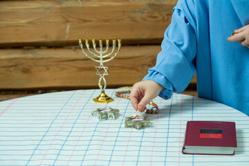 The hand of Jewish women at the table lights Shabbat candle