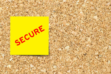 Yellow note paper with word secure on cork board background with copy space