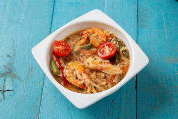 shrimp and rice vegetables pad thai sauce on a blue table. copy space