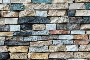 Close-up of a wall made of pieces of stone products of different colors. Background. Texture.