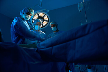 Surgeons team operating patient in operating room