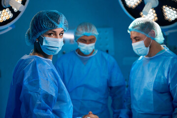 Surgeons in operating room with surgery equipment saving patient life