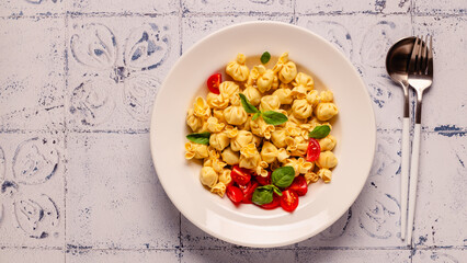Sacсhettini pasta in a plate with tomato sauce.