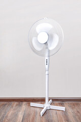 An electric fan is on the floor. Relief Help from the heat, hot summer. vertical photo