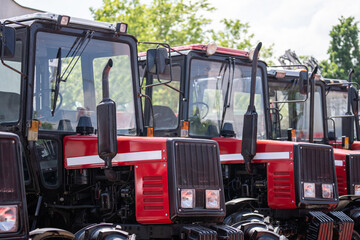 Row of red agricultural tractors for sale.