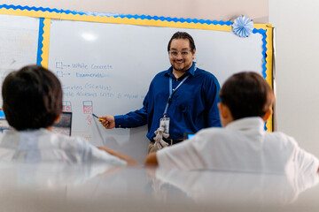 Adult Hispanic Professor Man Teacher front a Whiteboard.