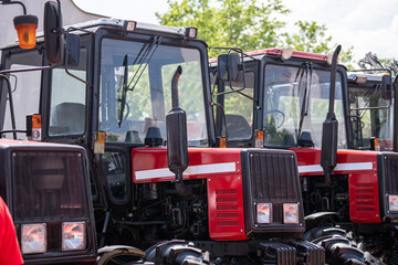 Row of red agricultural tractors for sale.