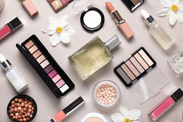 Flat lay composition with different makeup products and beautiful spring flowers on grey background