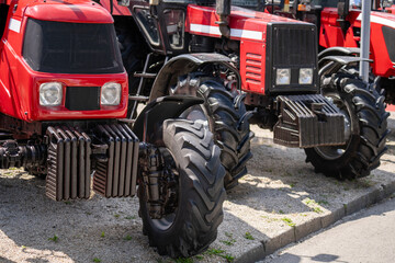 Row of red agricultural tractors for sale.
