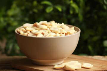 Fresh peanuts in bowl on table against blurred background