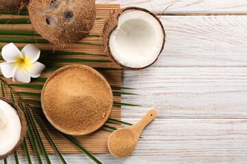 Coconut sugar, palm leaves, fruits and bamboo mat on wooden rustic table, flat lay. Space for text