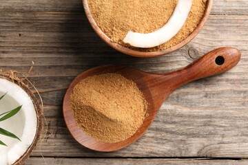 Coconut sugar in bowl, spoon and fruit on wooden table, flat lay