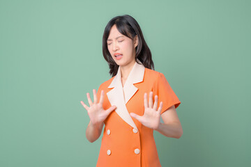 Woman in orange dress expressing distaste with eyes closed