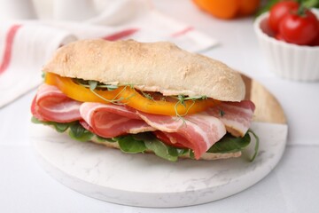 Tasty sandwich with bacon and bell pepper on white table, closeup