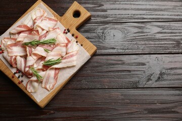 Slices of raw bacon and spices on wooden table, top view. Space for text