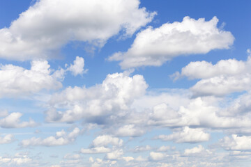 Blue sky with many white fluffy cumulus clouds texture, background