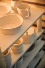 Clay mugs into kiln for firing pottery in workshop
