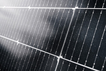 cells of a modern black solar panel in close up. Green renewable energy