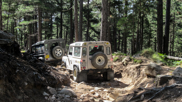 Close-up of the right rear part of a white land rover defender, off road vehicle prepared for overland travel and tourism, parked in the middle of the forest road on the top of the mountain, in front 