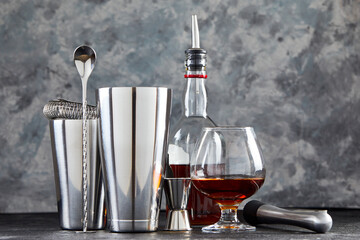 A set of bar accessories. A glass with a set of dishes for making cocktails. The concept of making alcoholic beverages.