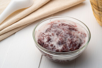 Black Glutinous Rice Pudding with coconut milk in glass bowl (kaow nieow dam piak)