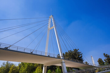 Obraz premium construction of a modern cable-stayed bridge on background of blue sky in Anhor Park in Tashkent in Uzbekistan. Uzbek new pedestrian suspension bridge