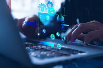 A businessman utilizes a notebook computer with a CRM emblem on the virtual screen, which represents Customer Relationship Management in company equipment.