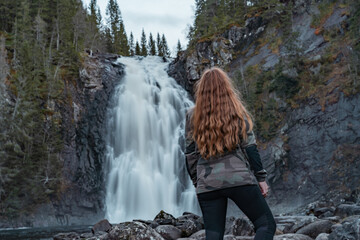 Woman looking at the beautiful waterfalls. 