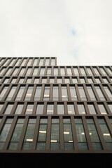 a tall glass building is illuminated by the sun as seen from below